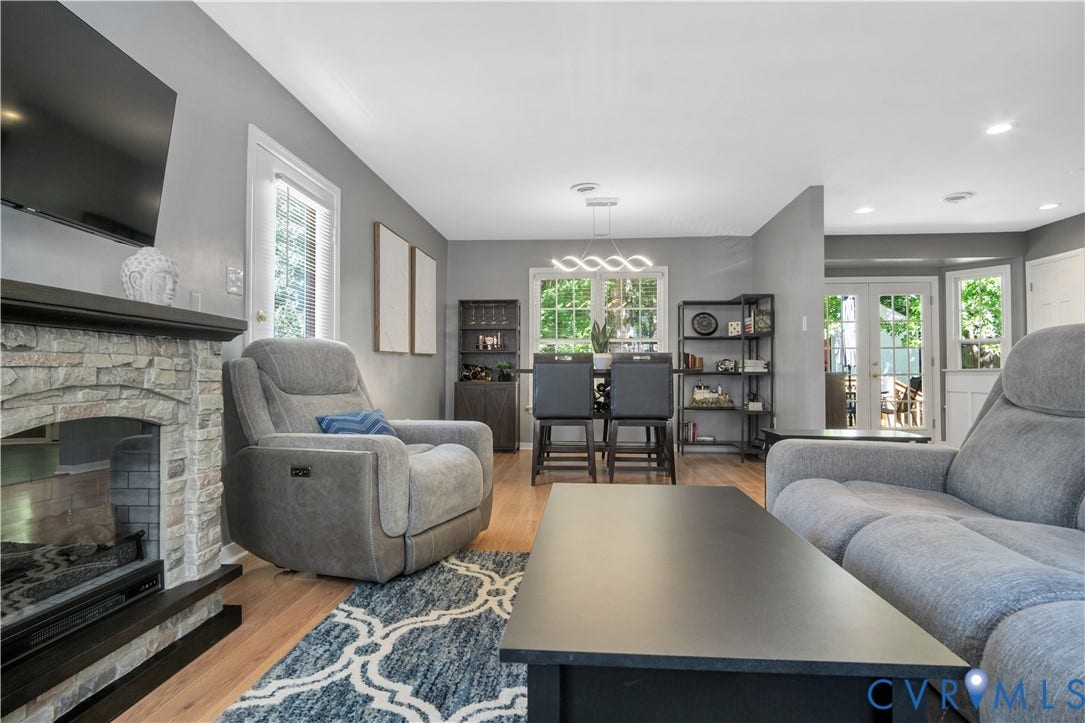 2724 Glen Point Circle, Henrico, VA 23233 Stone-clad fireplace with black mantel, wood-finish flooring, recessed lighting, and white trim windows
