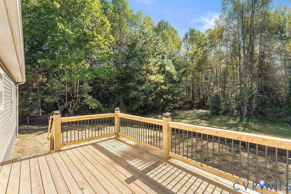 Outdoor wood deck with natural wood railing and dark metal balusters