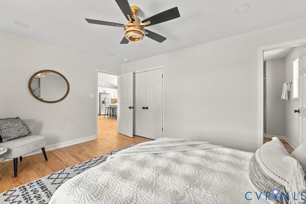 Wood-finish flooring throughout, bright white walls, and a recessed ceiling light