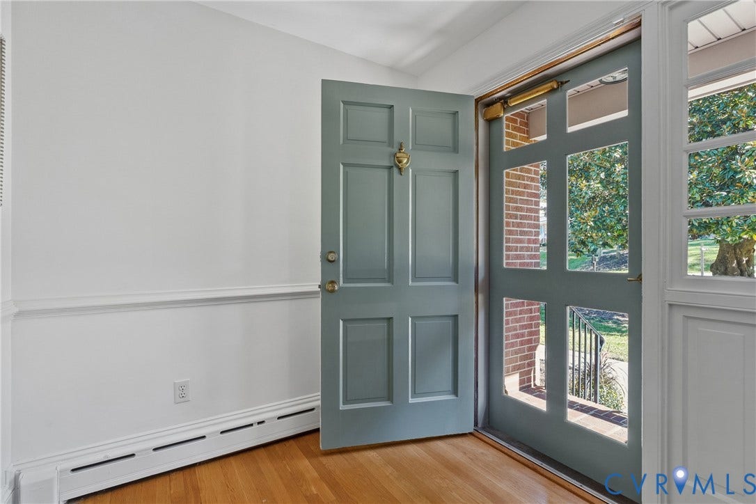 3700 Wakefield Road, Stratofrd Hills, Richmond, VA 23235 Entryway featuring wood-finish flooring, a six-panel door with a brass-finish knocker, and a glass-paneled storm door