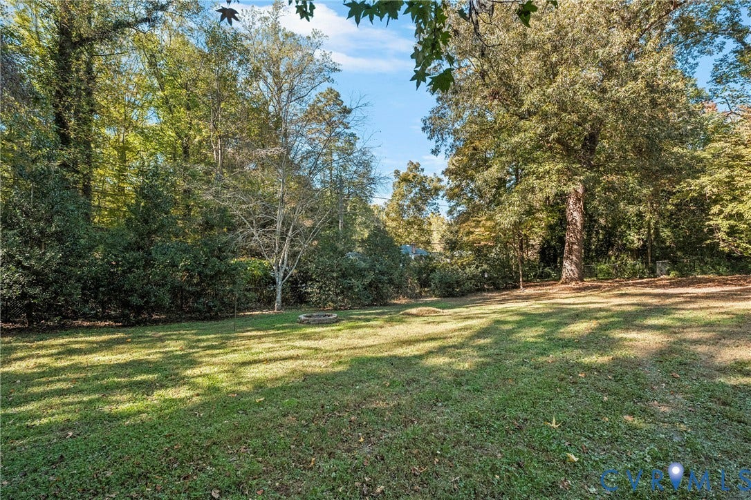 3700 Wakefield Road, Stratofrd Hills, Richmond, VA 23235 Expansive backyard featuring a lawn, stone fire pit, and perimeter of mature trees