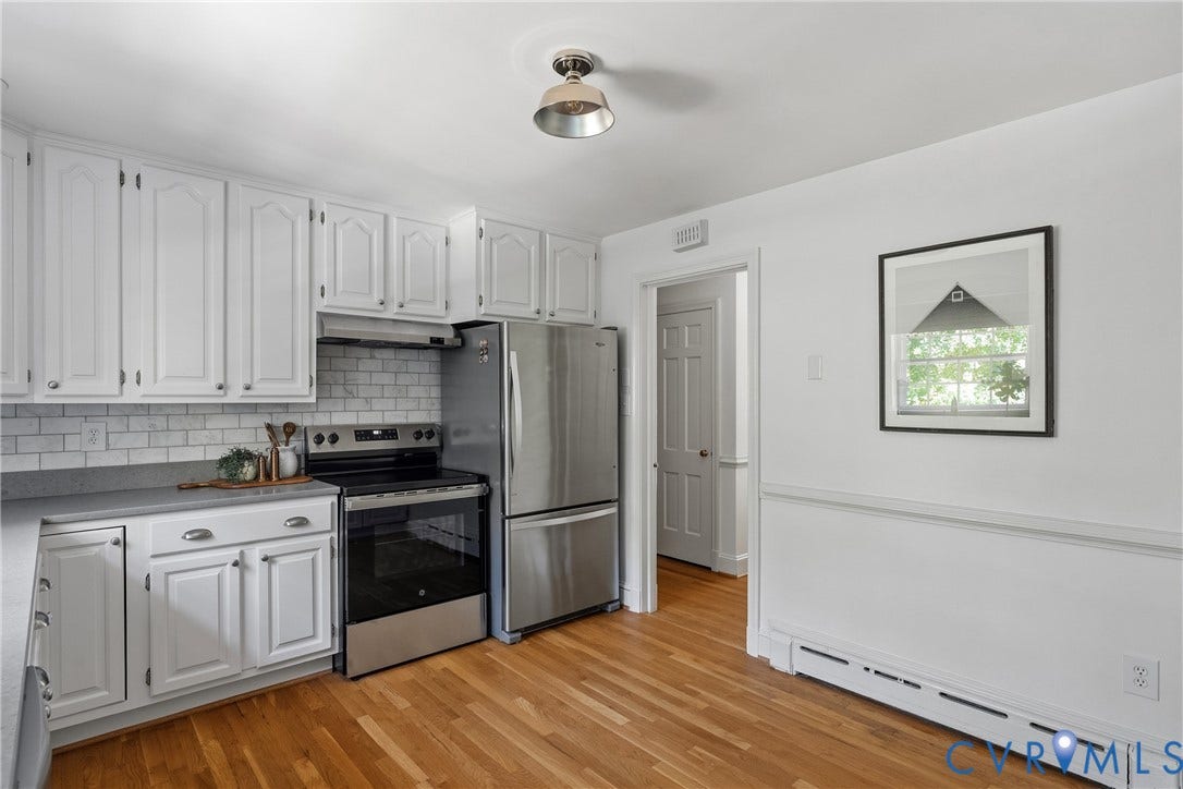 3700 Wakefield Road, Stratofrd Hills, Richmond, VA 23235 Kitchen featuring white cabinetry, subway tile backsplash, stainless steel appliances, wood-finish flooring, and crown-molding details