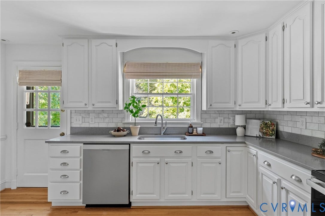 3700 Wakefield Road, Stratofrd Hills, Richmond, VA 23235 Kitchen featuring white recessed-panel cabinetry, solid-surface countertops, a white subway-tile backsplash, stainless steel dishwasher, and hardwood flooring