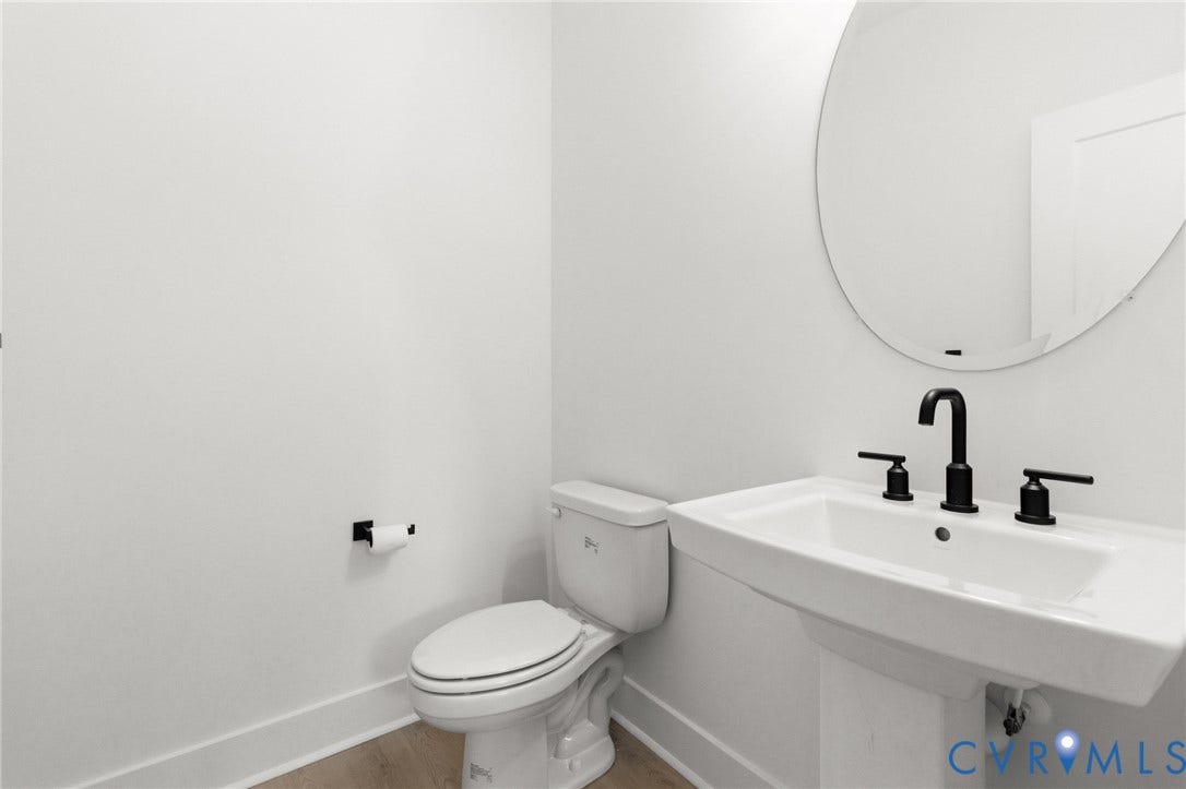 34356 Chinquapin Road, Waverly, VA 23890 Pedestal sink with matte black faucet, round wall mirror, and toilet with white finish