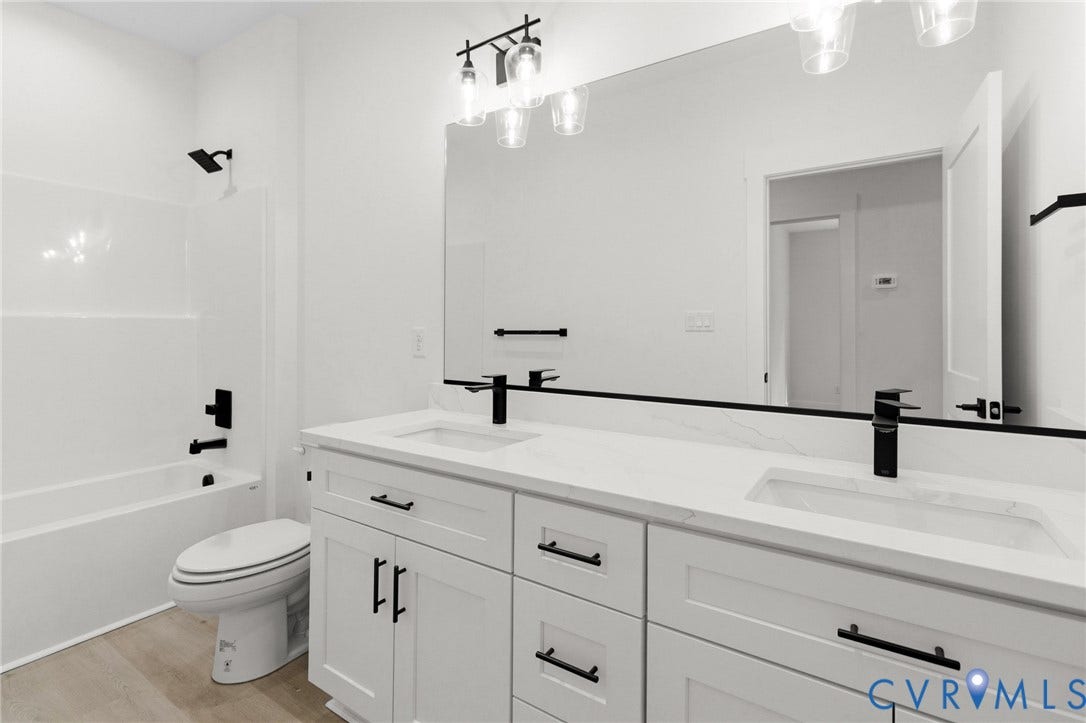 34356 Chinquapin Road, Waverly, VA 23890 Dual vanity with integrated sinks, white cabinetry, quartz-finish countertop, and matte black fixtures