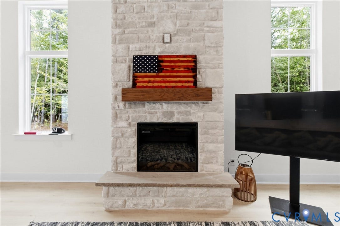 34356 Chinquapin Road, Waverly, VA 23890 Stone-clad fireplace featuring a wood mantel, an integrated firebox, and a stone hearth