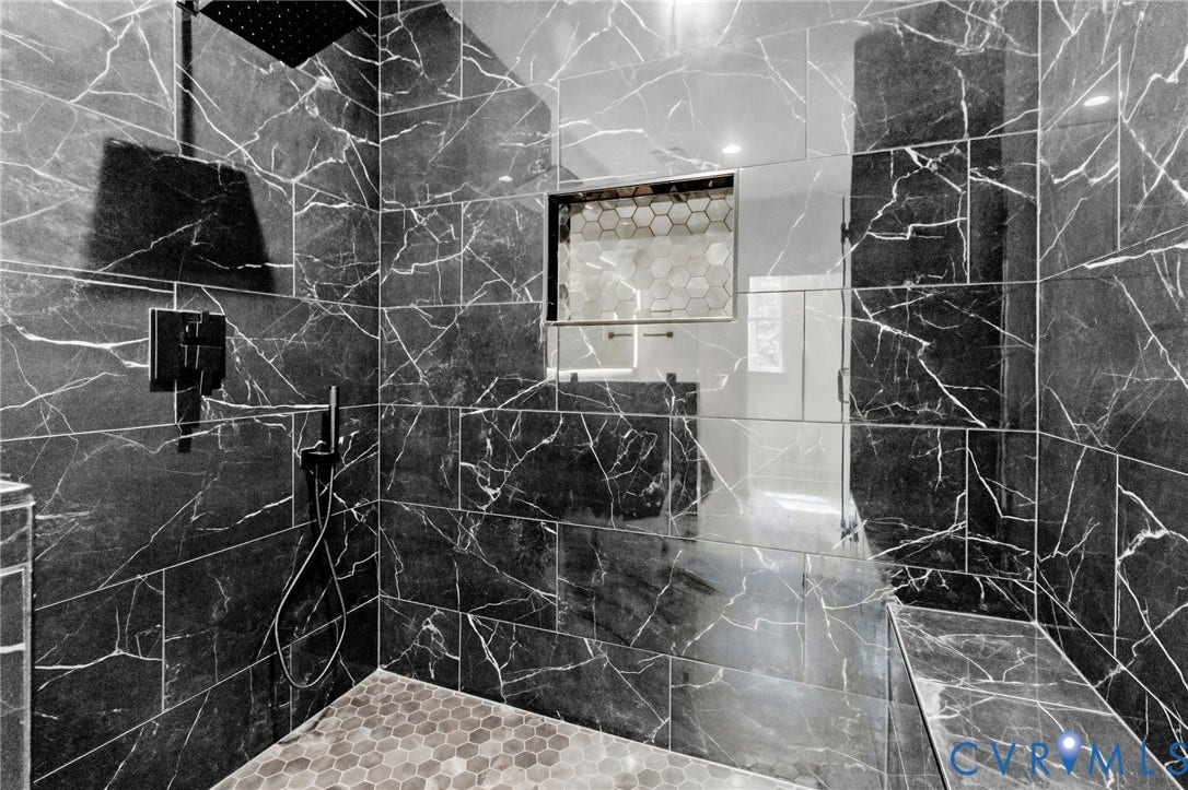 34356 Chinquapin Road, Waverly, VA 23890 Walk-in shower with dark tile walls, integrated shower niche with hexagonal tile, and a built-in shower bench