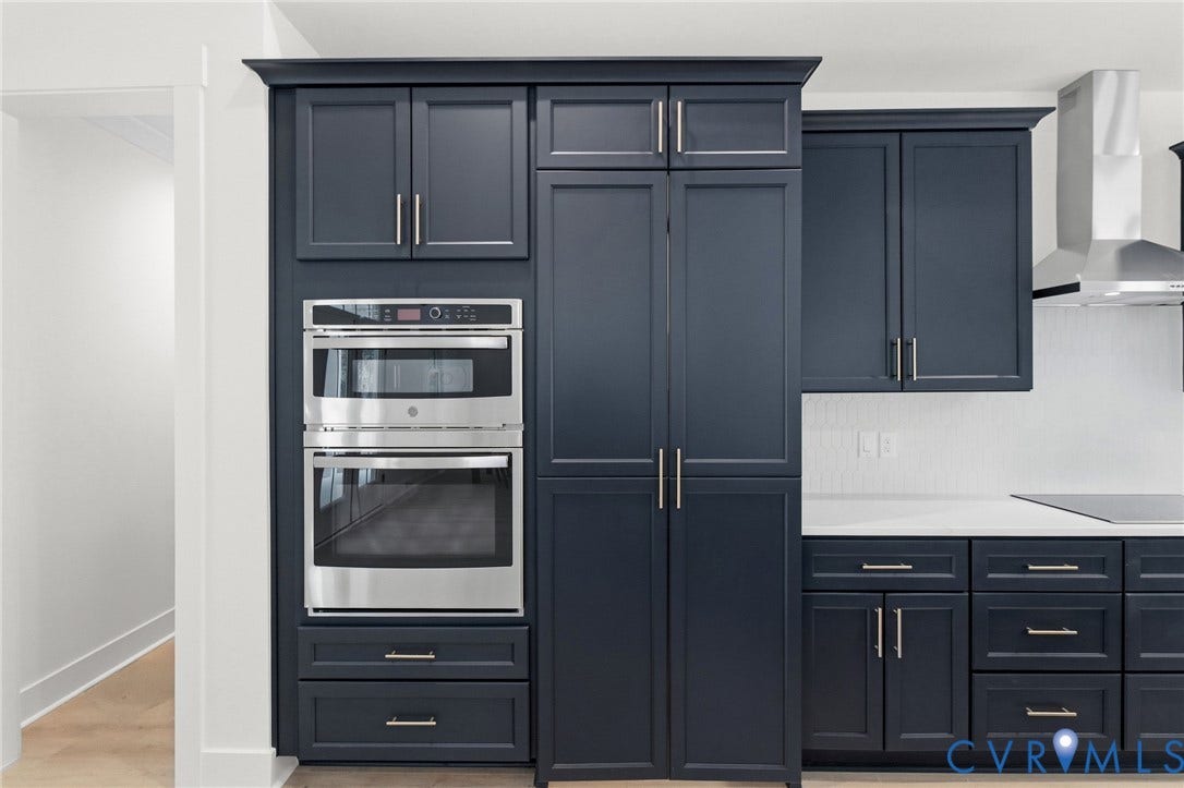 34356 Chinquapin Road, Waverly, VA 23890 Built-in stainless steel double ovens, deep blue shaker-style cabinetry, white quartz countertops, and a subway tile backsplash