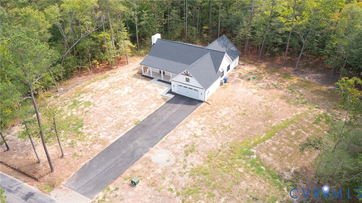 34356 Chinquapin Road, Waverly, VA 23890 Single-story residence featuring a dark shingle roof, white siding, an attached two-car garage, an asphalt driveway, and a covered porch with white columns