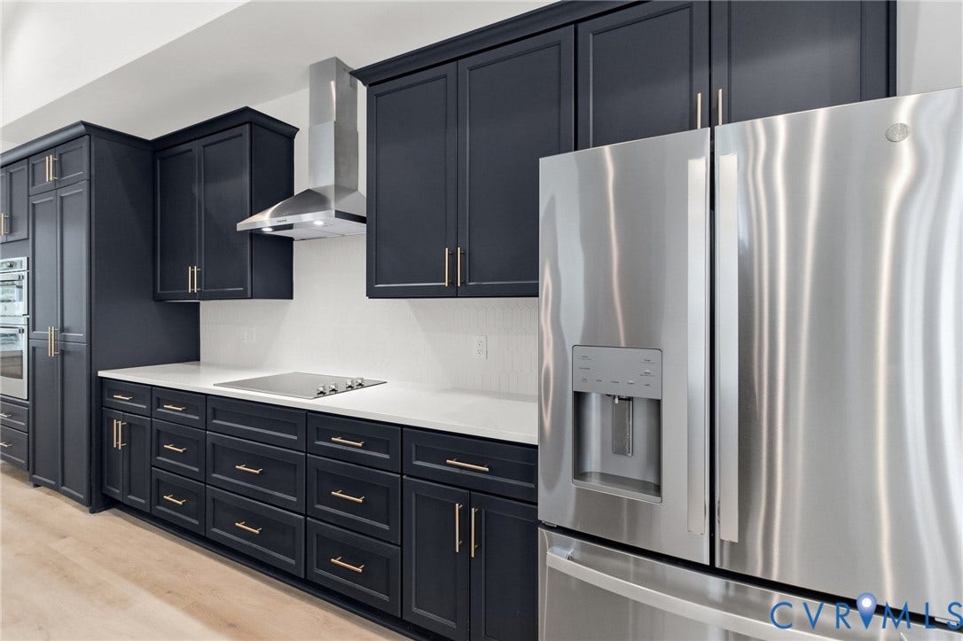 34356 Chinquapin Road, Waverly, VA 23890 Dark cabinetry with gold-tone hardware, white countertops, built-in stainless steel appliances, and a tile backsplash