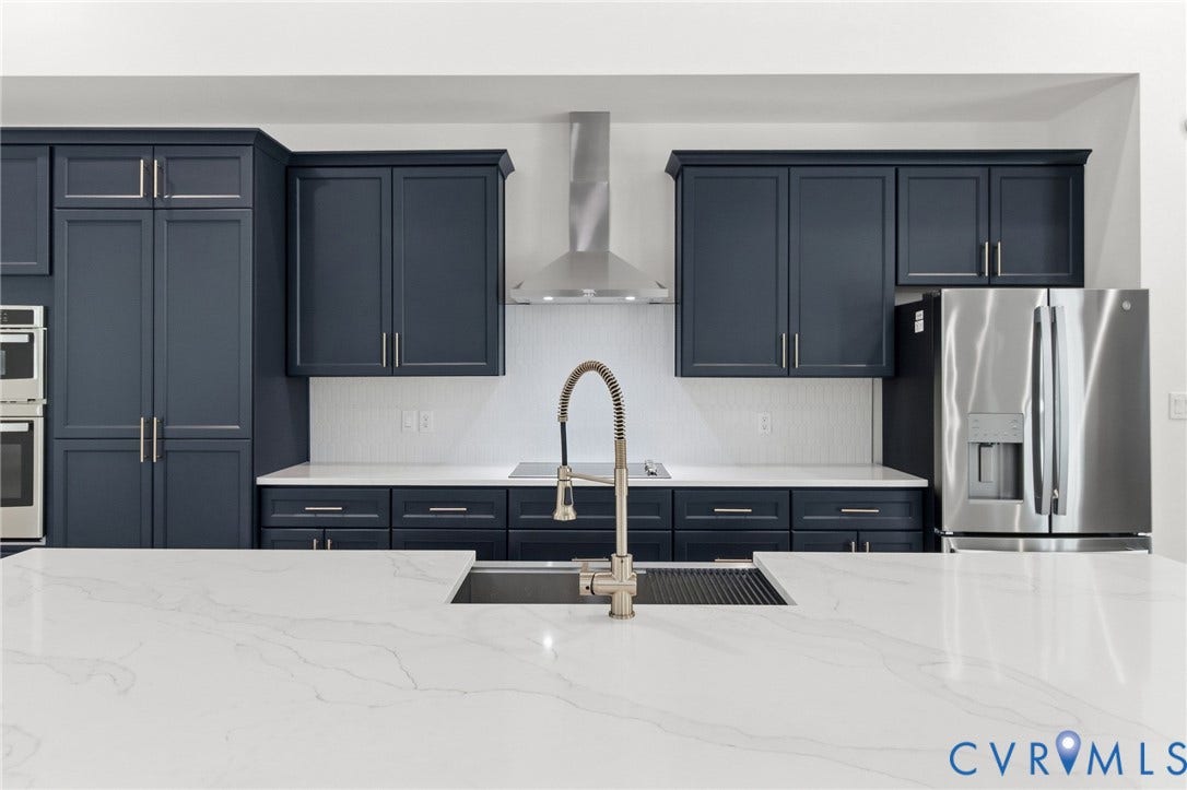 34356 Chinquapin Road, Waverly, VA 23890 Expansive island with integrated sink, white countertops, dark cabinetry, and stainless steel appliances