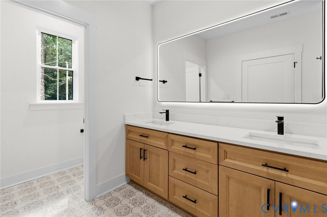 34356 Chinquapin Road, Waverly, VA 23890 Dual vanity with wood-finish cabinetry, white countertop, and integrated sinks