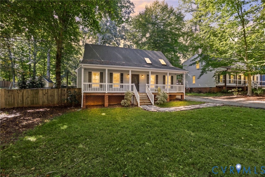 13811 Buck Rub Drive, Chesterfield, VA 23112 Light gray siding exterior with a dark shingle roof, featuring a covered front porch with white railings, and two skylights