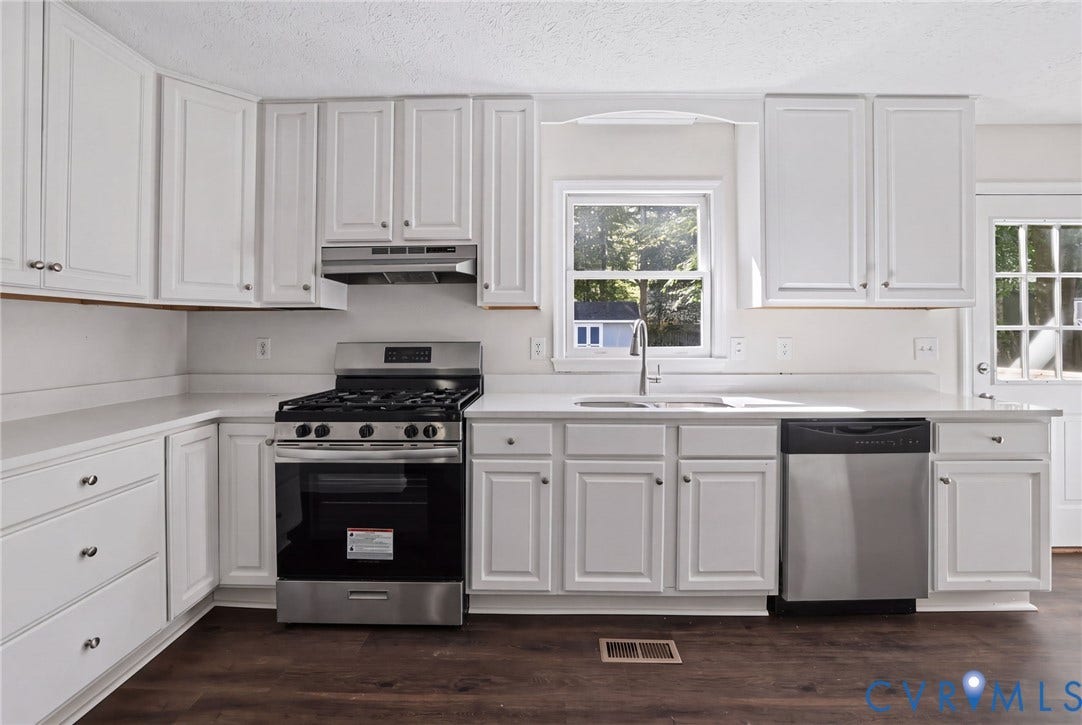 13811 Buck Rub Drive, Chesterfield, VA 23112 Kitchen featuring white shaker-style cabinetry, stainless steel appliances, solid surface countertops, a stainless steel sink with a gooseneck faucet, and wood-finish flooring