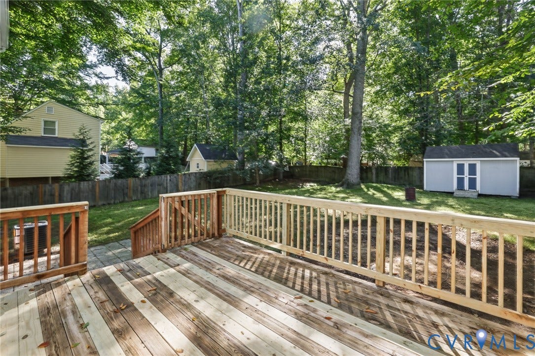 13811 Buck Rub Drive, Chesterfield, VA 23112 Expansive wood deck with natural wood railing, leading to a paver patio and grassy yard with mature trees