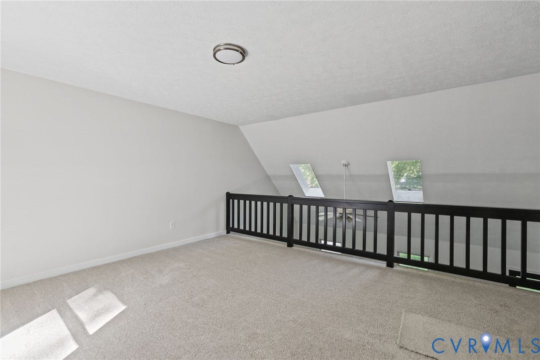 13811 Buck Rub Drive, Chesterfield, VA 23112 Carpeted loft area featuring an angled ceiling, two skylight windows, and a dark wood-finish railing