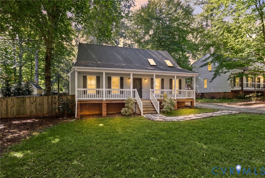 13811 Buck Rub Drive, Chesterfield, VA 23112 Cottage-style residence featuring a covered front porch with white railings, a stone pathway, a dark shingle roof with skylights, and a partial brick foundation