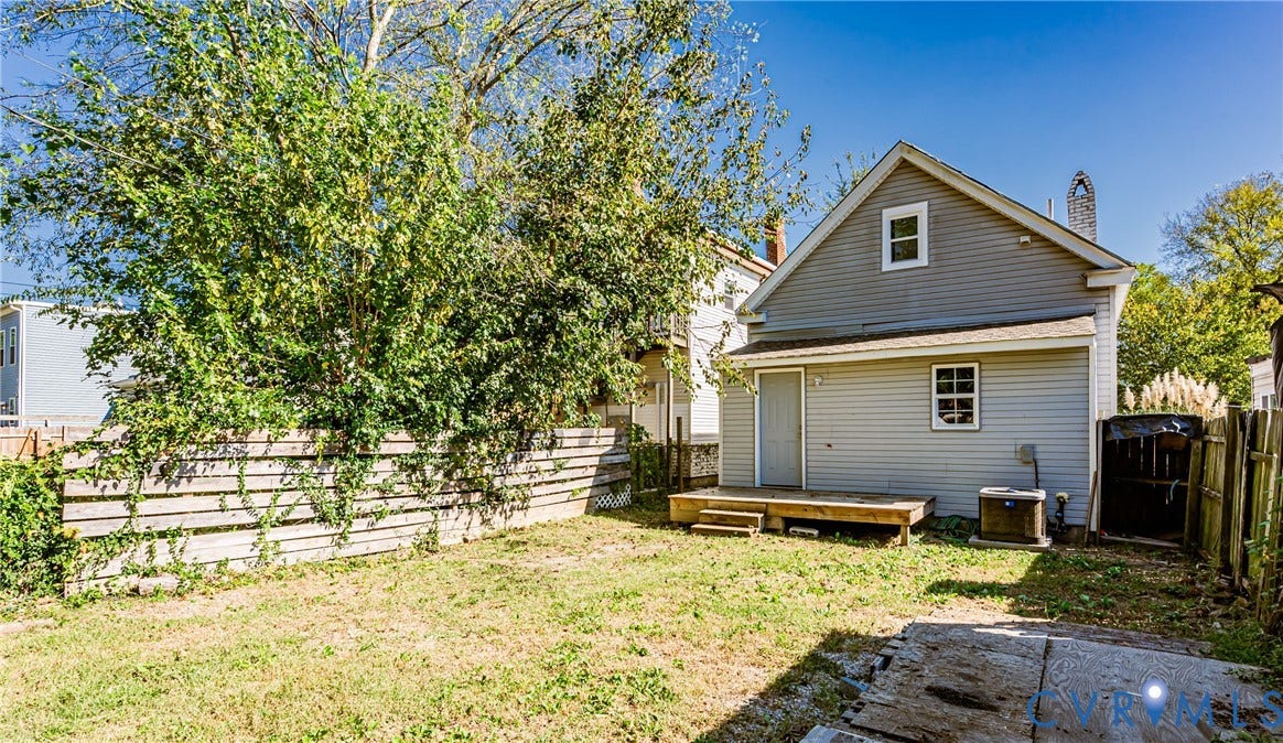 2011 Chicago Avenue, Richmond, VA 23224 Exterior rear elevation featuring light-colored horizontal siding, a wooden deck, and a fenced backyard
