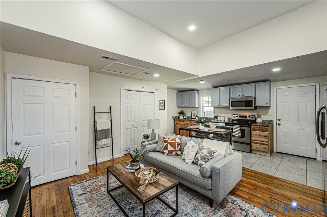 2011 Chicago Avenue, Richmond, VA 23224 Open-concept interior featuring vaulted ceilings, wood-finish flooring, recessed lighting, and kitchen cabinetry with a mix of neutral-toned upper and natural wood-tone lower finishes