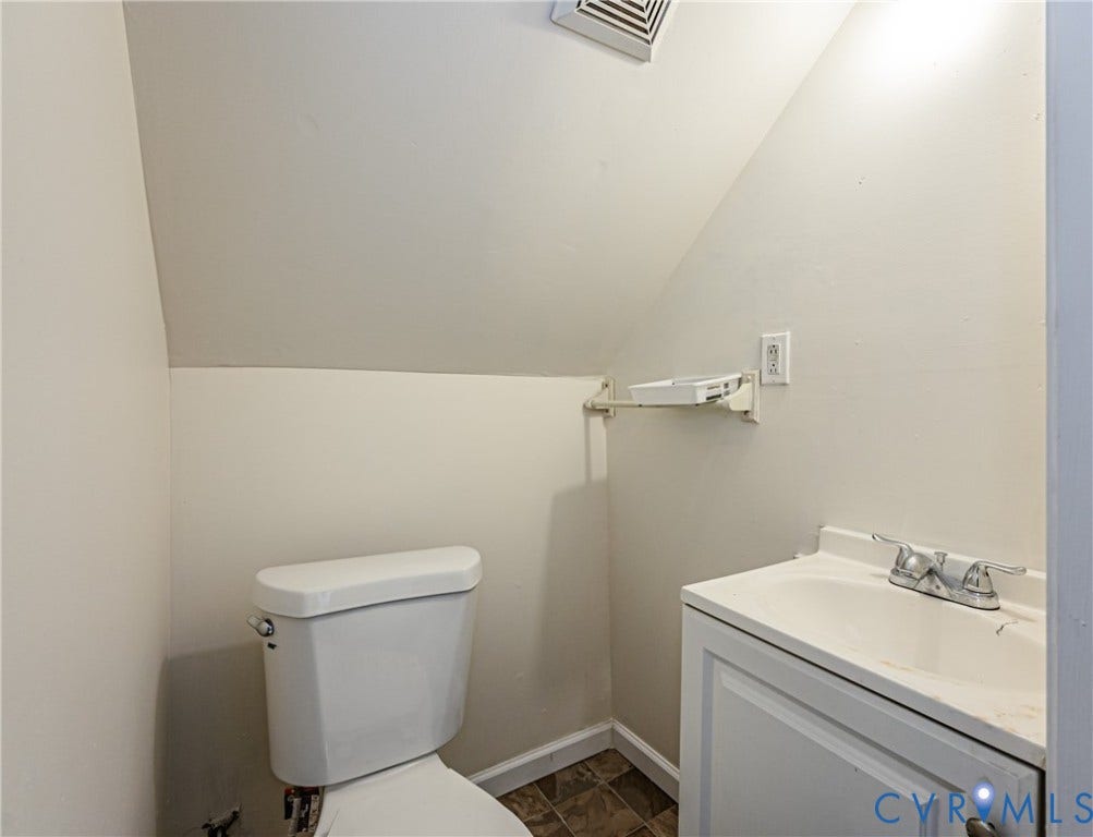 2011 Chicago Avenue, Richmond, VA 23224 White vanity cabinet with an integrated sink, dual-handle chrome faucet, and white porcelain toilet