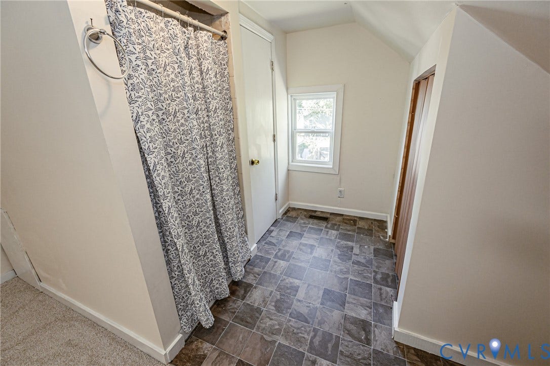 2011 Chicago Avenue, Richmond, VA 23224 Multi-tonal stone-look tile flooring, single-pane window with white trim, and interior wood-panel door