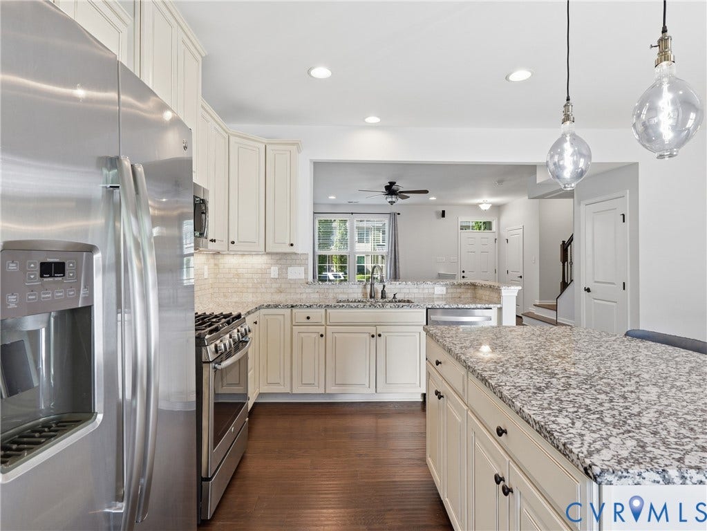 5612 Riverside Heights Way, Richmond, VA 23225 Light cabinetry, granite countertops, and stainless steel appliances give the kitchen a clean, classic look.