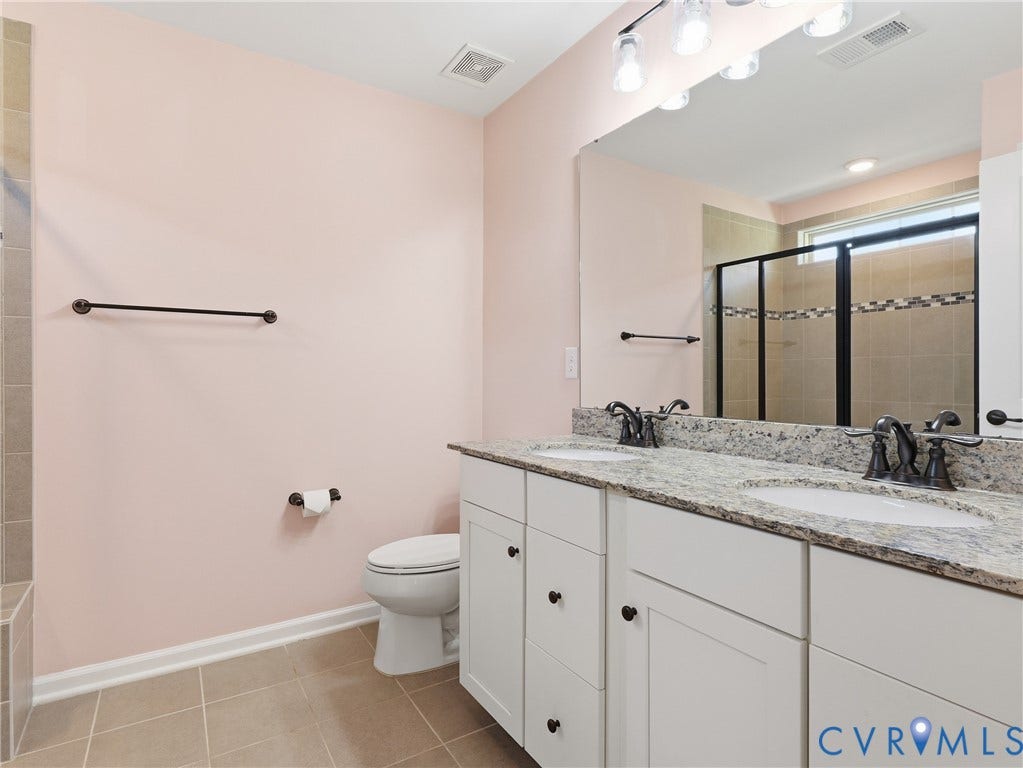 5612 Riverside Heights Way, Richmond, VA 23225 Primary ensuite bathroom featuring a double vanity, glass shower, and cabinet storage