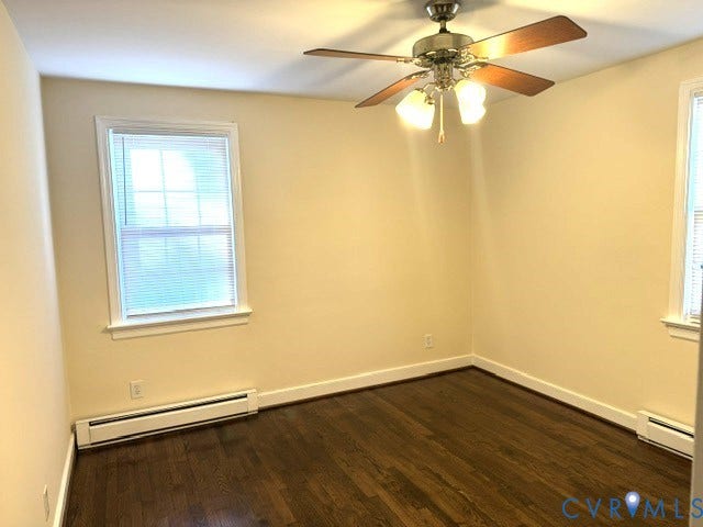 Hardwood-style flooring, ceiling fan with integrated lighting, single window, and baseboard heating units