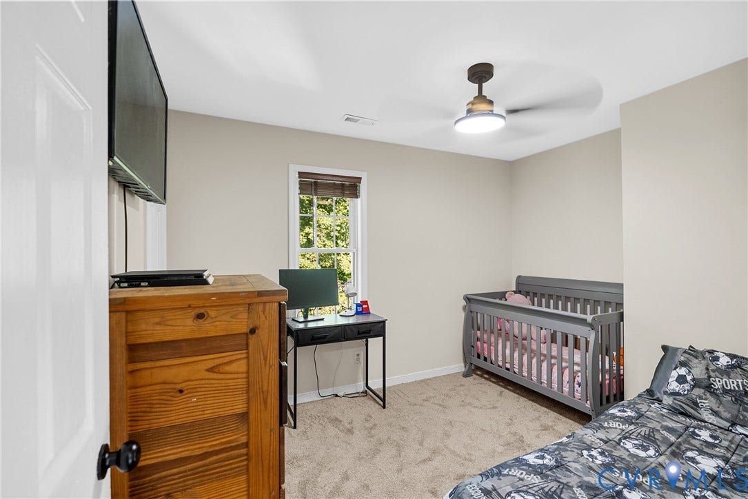 11512 Wiltstaff Drive, Midlothian, VA 23112 Neutral-toned bedroom featuring carpeted flooring, a multi-pane window with a woven shade, and a flush-mount ceiling fan with an integrated light fixture