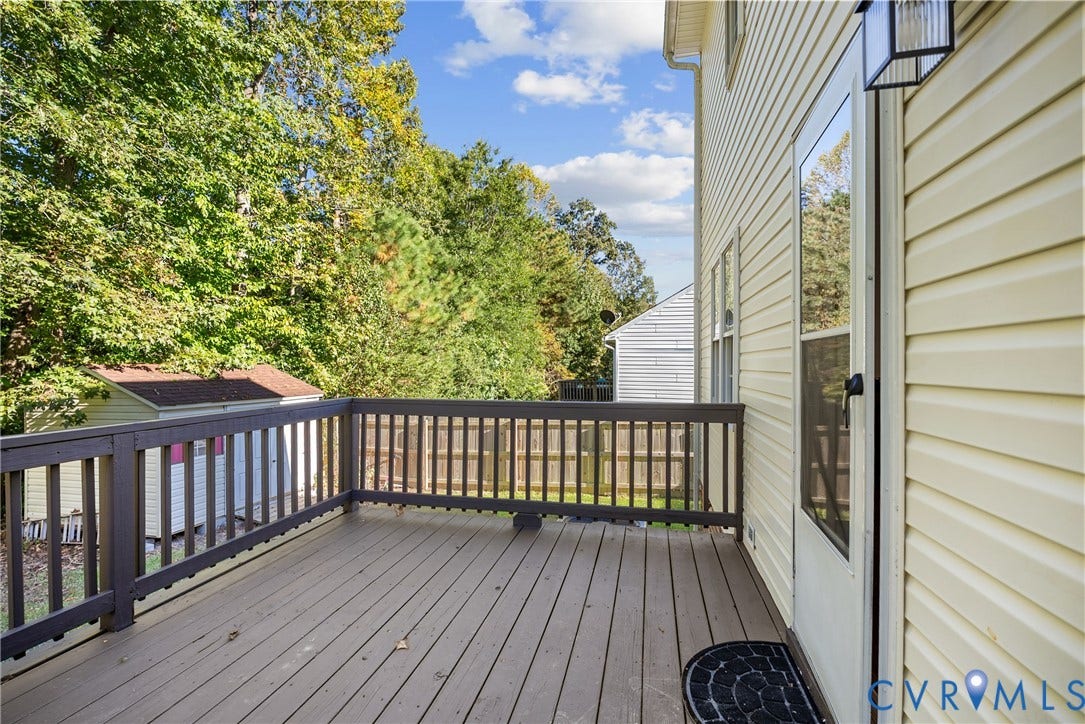 11512 Wiltstaff Drive, Midlothian, VA 23112 Raised deck with wood-finish decking and dark-toned railings, light-colored vinyl siding, and exterior wall-mounted lighting