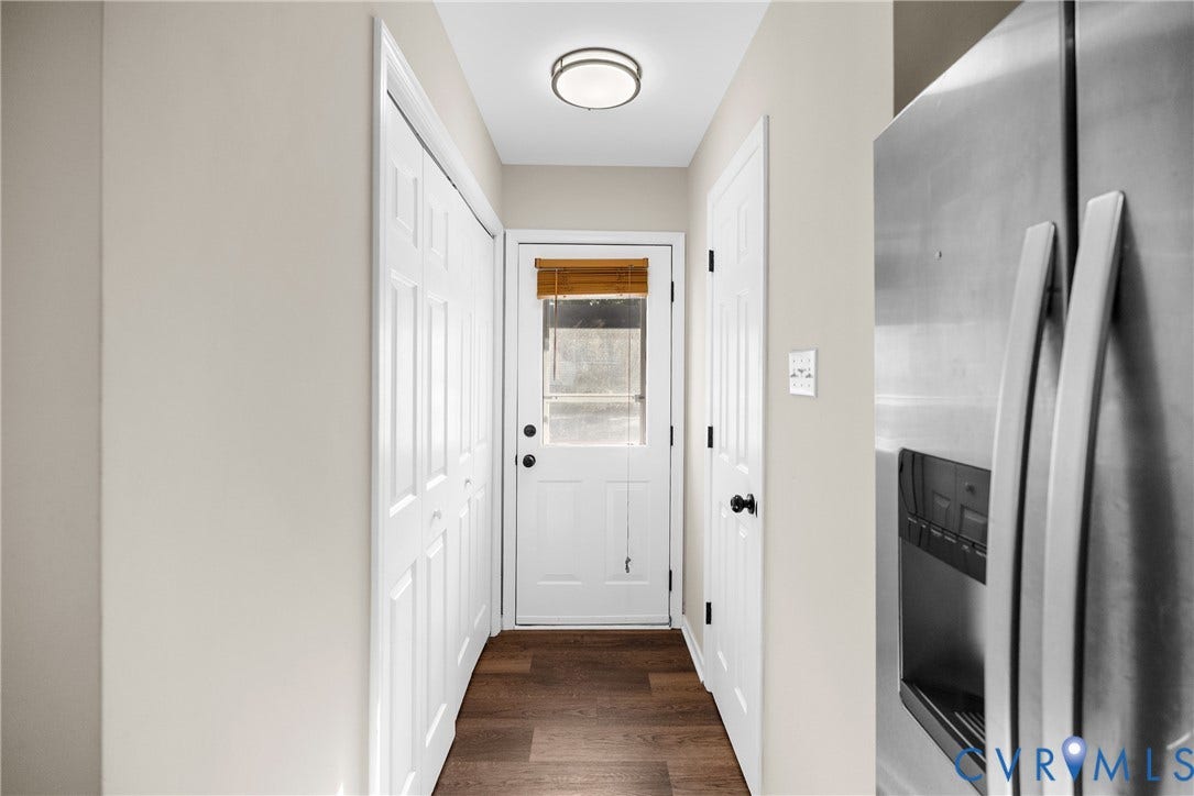 11512 Wiltstaff Drive, Midlothian, VA 23112 Hallway featuring wood-finish flooring, a white six-panel door with a glass insert, dual bifold closet doors, and a circular flush-mount ceiling light fixture