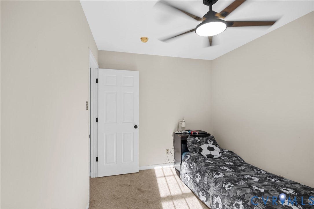 11512 Wiltstaff Drive, Midlothian, VA 23112 Neutral-toned interior space featuring neutral carpeting, a multi-panel door, and a ceiling fan with integrated LED lighting