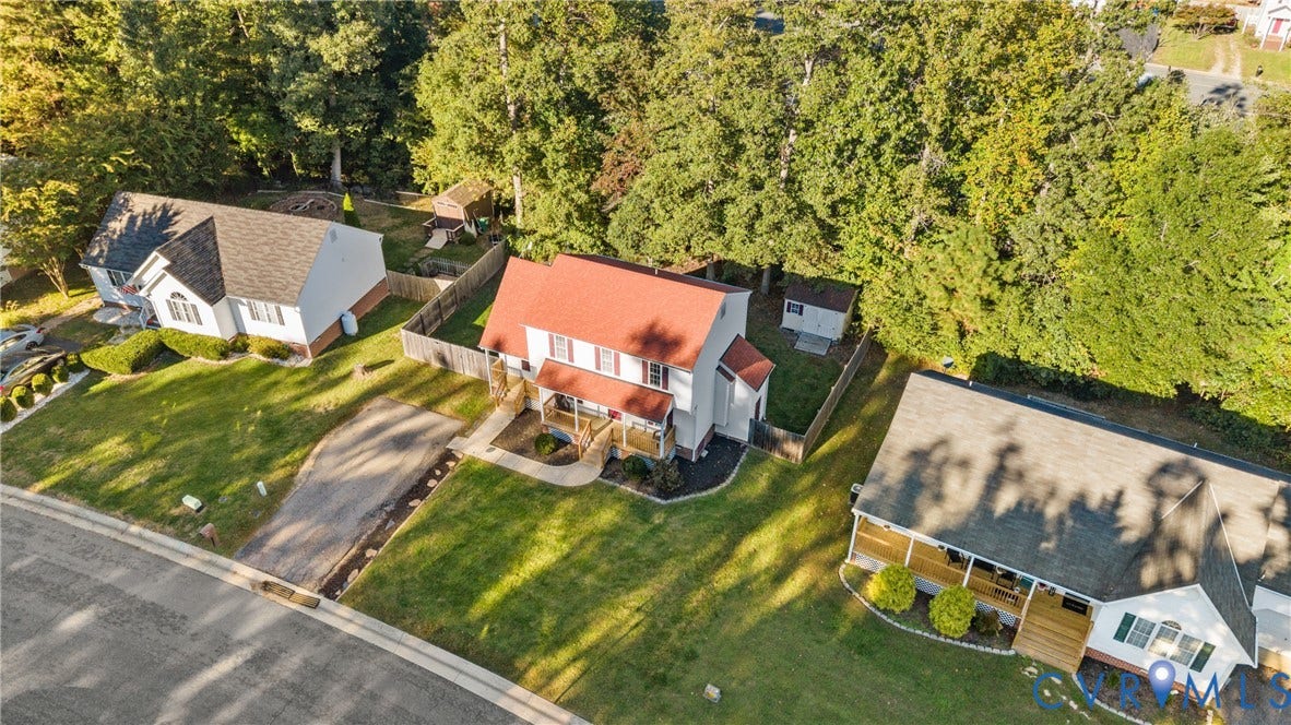11512 Wiltstaff Drive, Midlothian, VA 23112 Two-story residential structure featuring a red metal roof, covered front entryway, asphalt driveway, and private fenced yard space