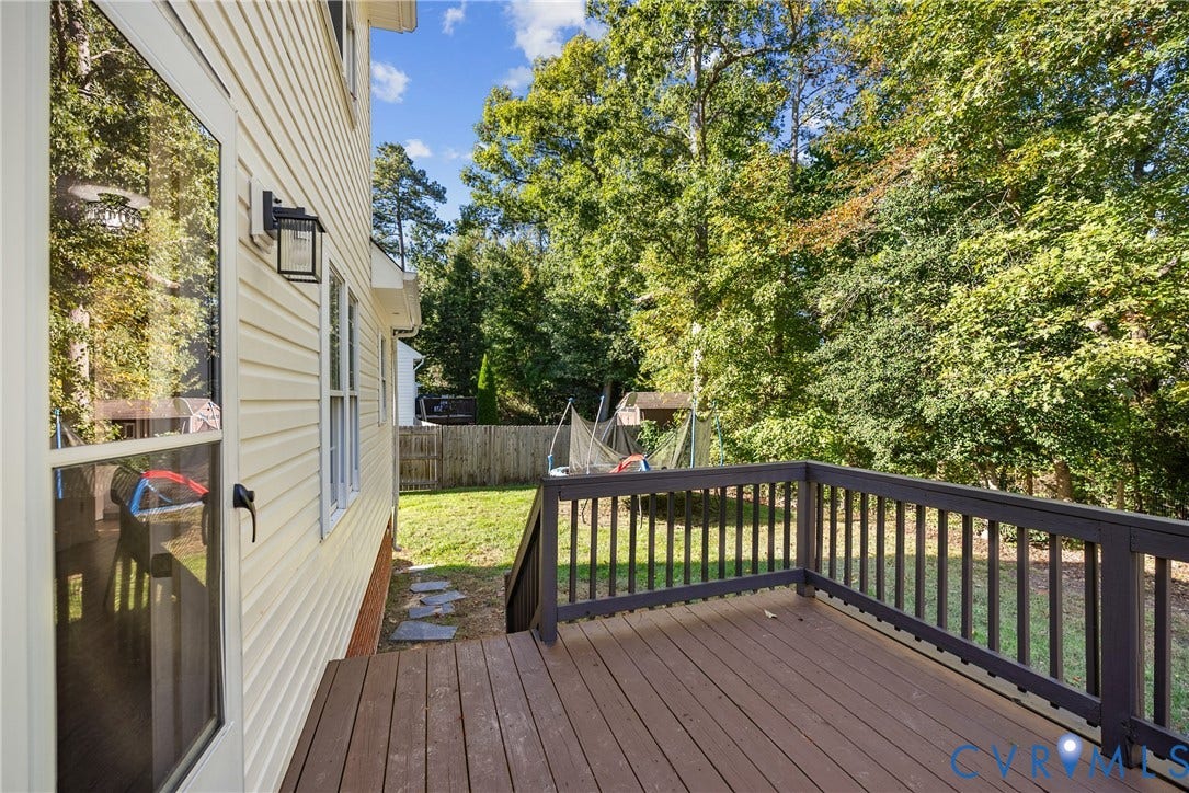 11512 Wiltstaff Drive, Midlothian, VA 23112 Exterior deck featuring dark wood-finish planking and dark-toned railings, light-colored vinyl siding, and wall-mounted outdoor lighting