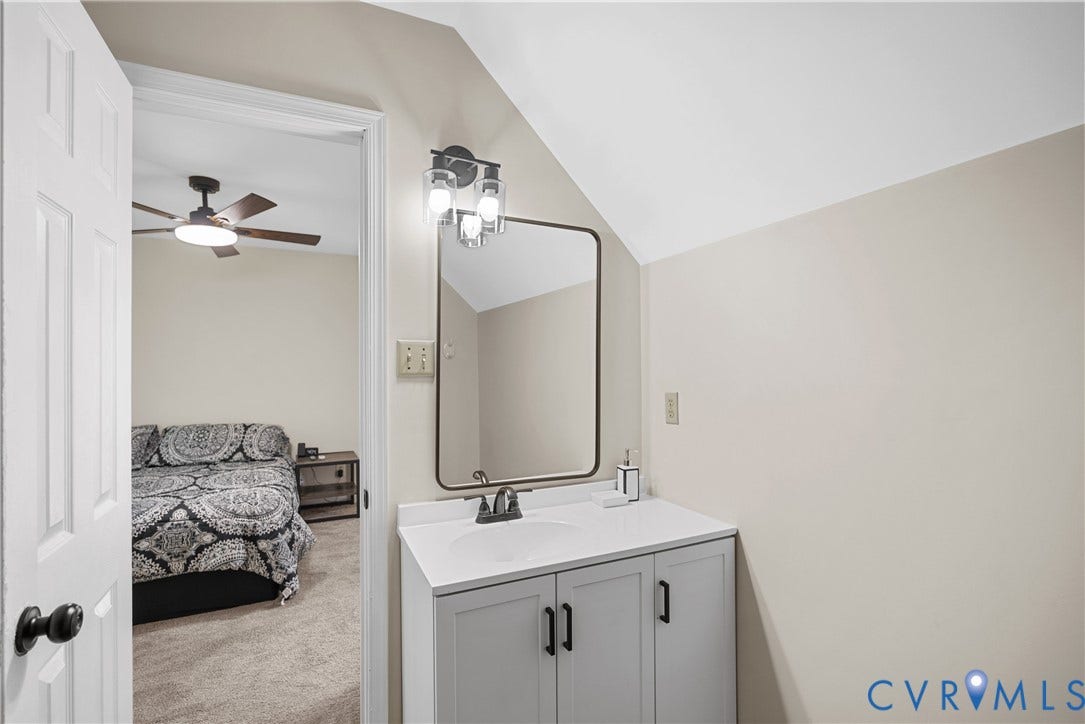11512 Wiltstaff Drive, Midlothian, VA 23112 Vanity featuring light gray cabinetry, white countertop with integrated sink, matte black hardware, rectangular mirror with thin dark frame, and three-bulb vanity light fixture