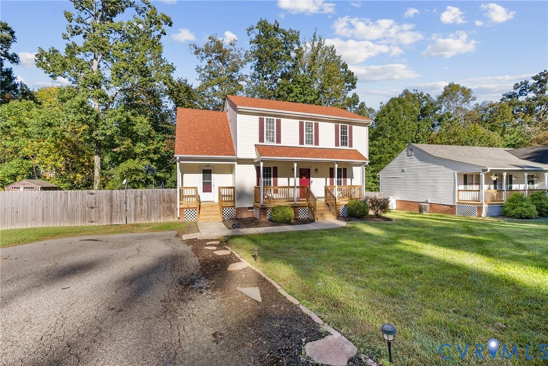 11512 Wiltstaff Drive, Midlothian, VA 23112 Two-story residence featuring light-colored siding, a metal-roofed covered front porch, decorative shutters, and a wood privacy fence