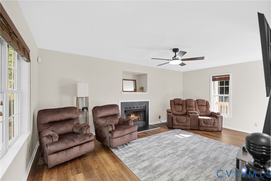 11512 Wiltstaff Drive, Midlothian, VA 23112 Living area featuring wood-finish flooring, a recessed fireplace with a dark surround, a built-in display niche, and a multi-blade ceiling fan with integrated lighting