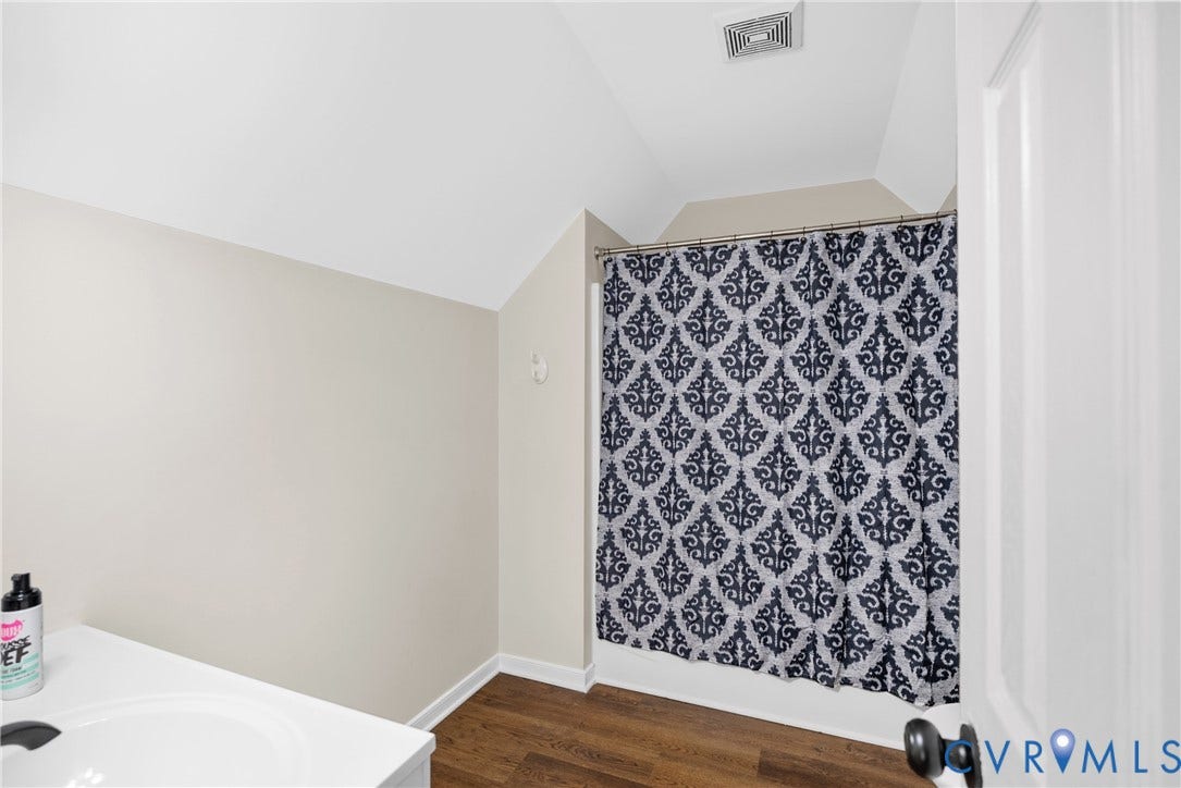 11512 Wiltstaff Drive, Midlothian, VA 23112 Bathroom featuring wood-finish flooring, vaulted ceilings, and a shower-tub combination