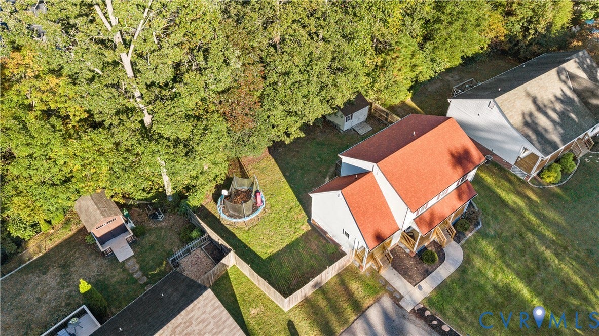 11512 Wiltstaff Drive, Midlothian, VA 23112 Aerial perspective featuring a multi-level structure with a red roof, enclosed by wooden fencing, accompanied by a detached storage shed and mature trees