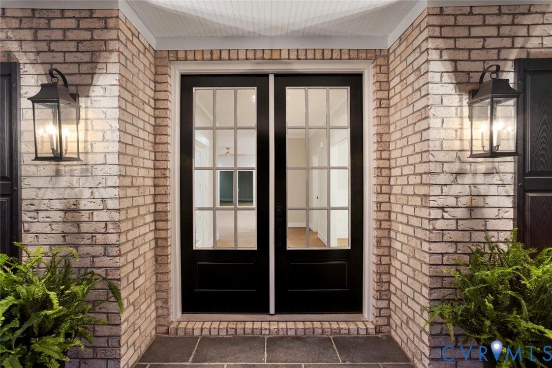 14010 Summercliff Trail, Chesterfield, VA 23832 Exterior entrance featuring light brick masonry, double glass-paneled doors with grid detailing, and two wall-mounted metal lanterns