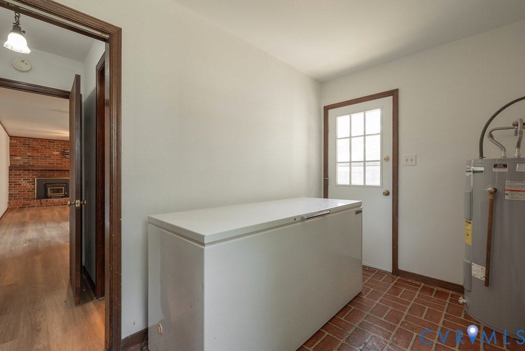Tiled floor entryway with a paneled exterior door and wood trim
