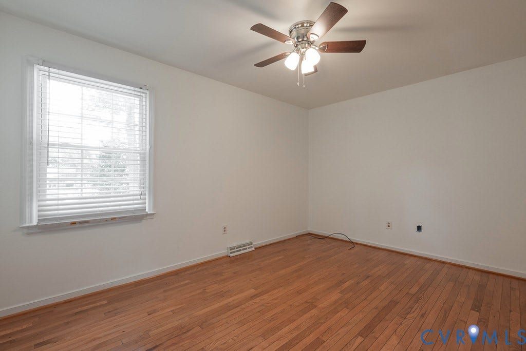 Hardwood flooring, painted walls, ceiling fan with light fixture, and window with blinds