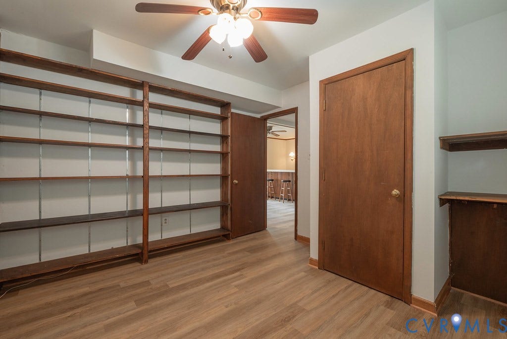 Wood-finish flooring throughout, built-in shelving, and a ceiling fan