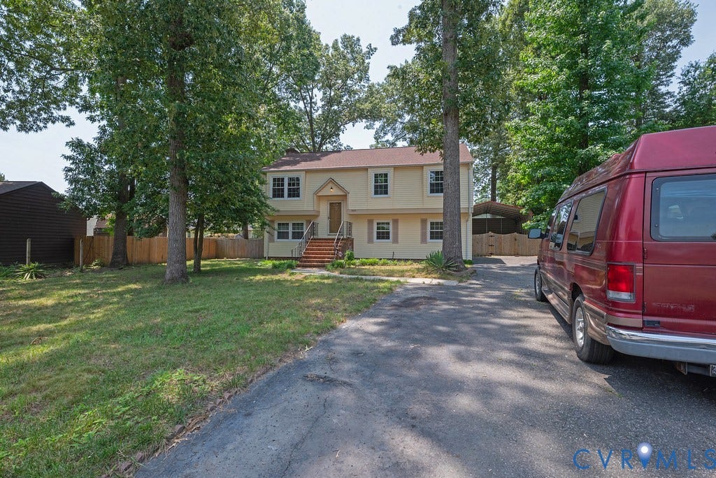 Two-story residence with a light-colored exterior and a brown roof