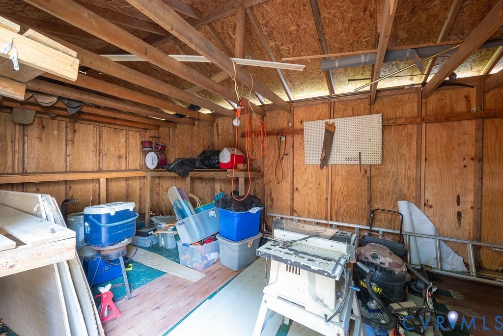 Wood-paneled storage shed with exposed wood beams and shelving