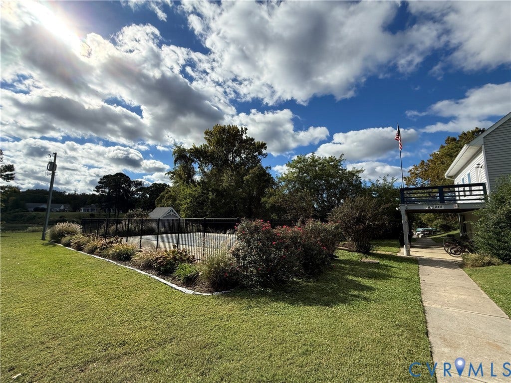 #30 Molly's Way, Urbanna, VA 23175 Expansive lawn with manicured landscaping, fenced area, detached shed, and elevated deck structure
