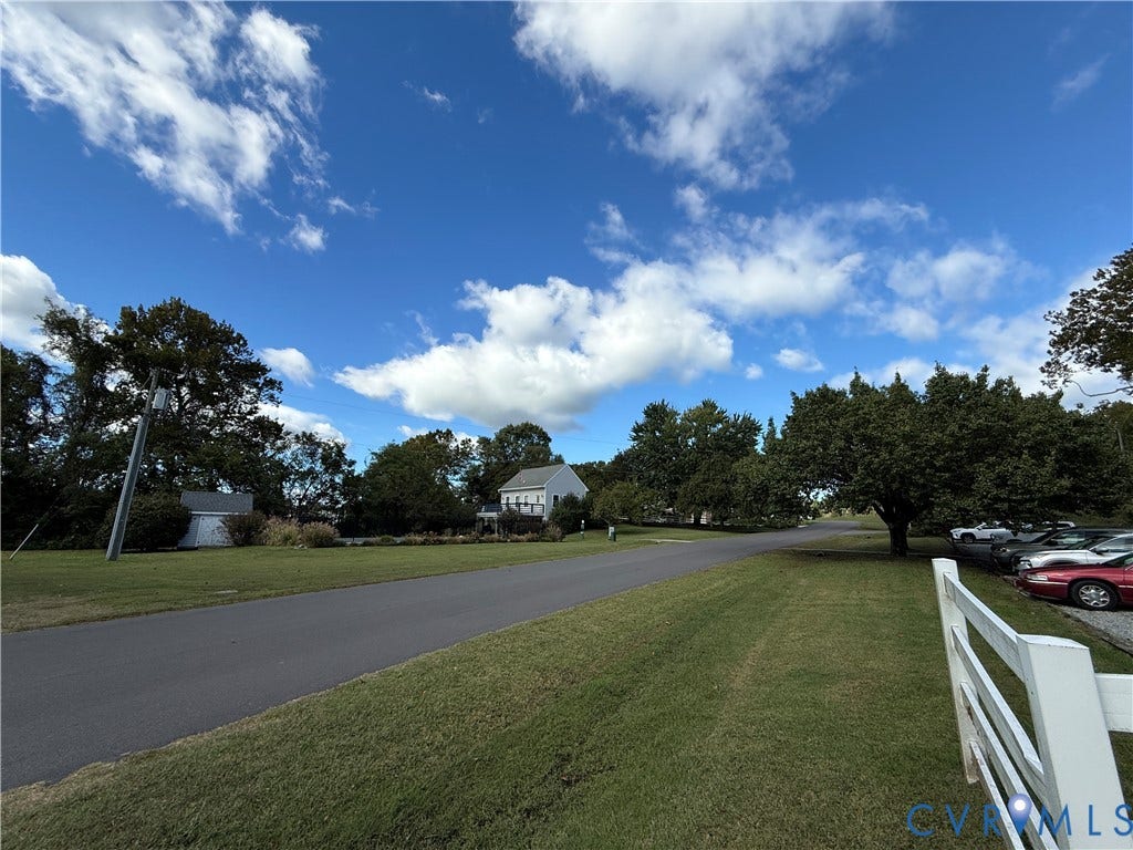 #30 Molly's Way, Urbanna, VA 23175 Expansive lawn area with mature trees and a paved street