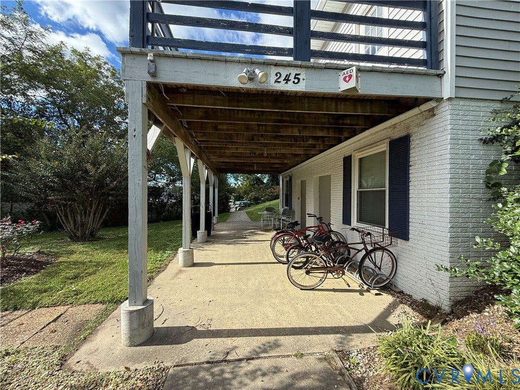 #30 Molly's Way, Urbanna, VA 23175 Covered patio area with concrete flooring, supported by multiple columns, and white brick exterior
