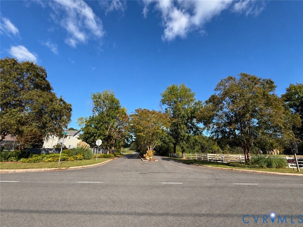 #30 Molly's Way, Urbanna, VA 23175 Roadway with a central landscaped island featuring mature trees and established greenery