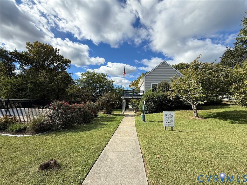 #30 Molly's Way, Urbanna, VA 23175 Manicured lawn with mature trees and shrubbery, concrete pathway, and a fenced area